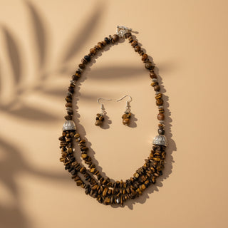 Necklace and earrings set with brown beads on a beige background